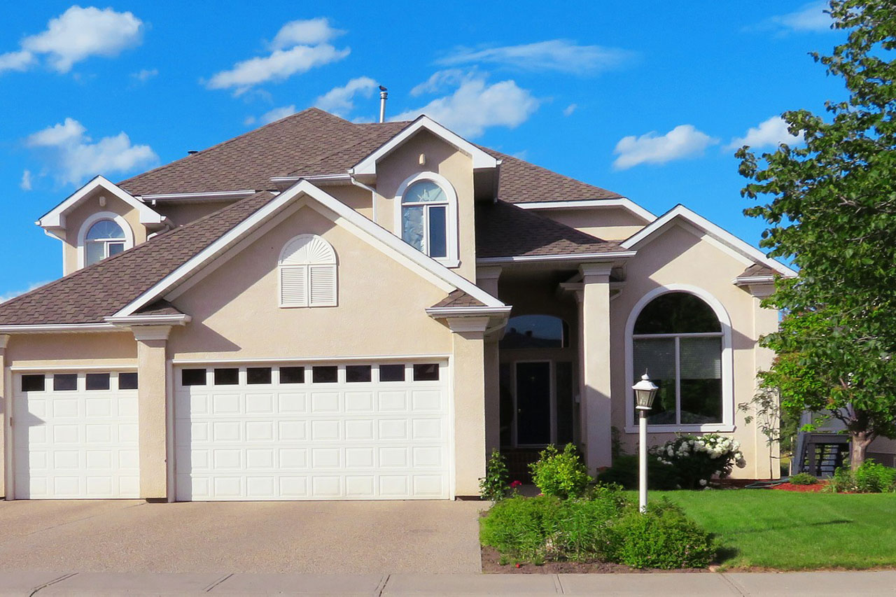 Two-story house with arched windows and a front lawn